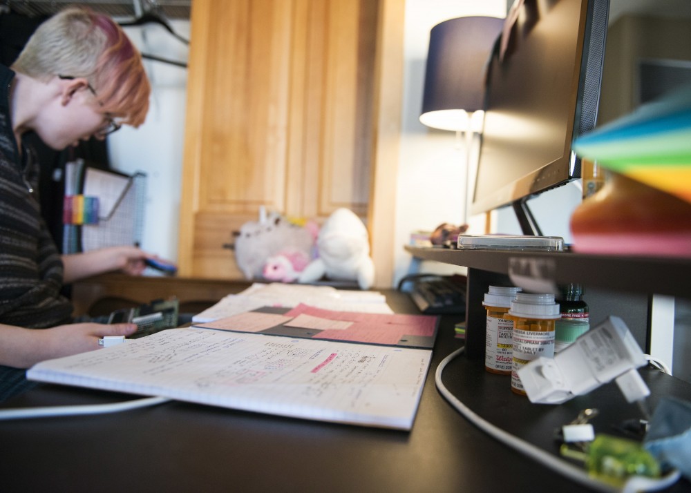Pill bottles grouped together, hide beneath an awning on 19-year-old Vee Livermores desk, where they study on March 21. One bottle holds a daily preventative medication Livermore takes to fight off migraines.