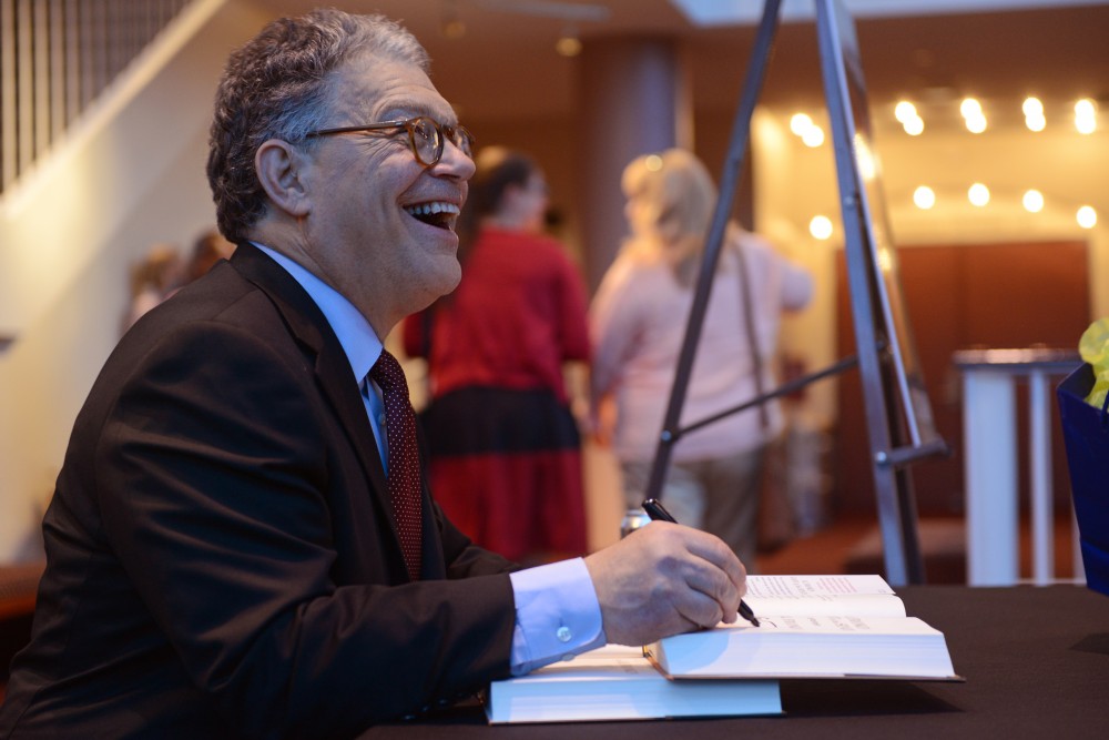 Senator Al Franken laughs while signing a copy of his book, Al Franken, Giant of the Senate, on Friday, June 2 at the Ted Mann Theater on West Bank.