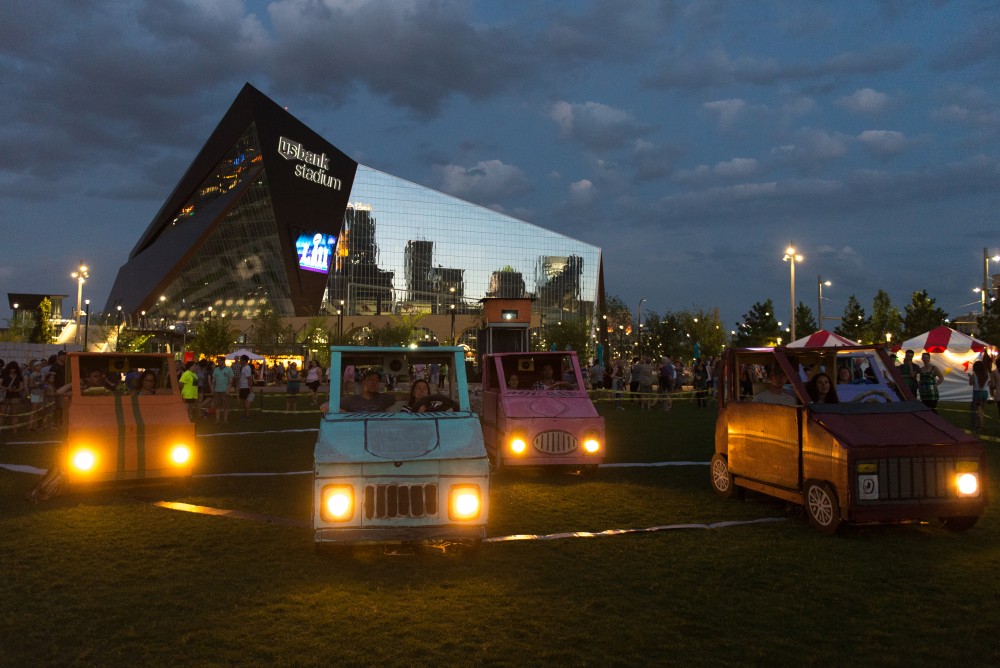 Attendees sit in cardboard cars and take part in a interactive instillation “Traffic Jam Scene, 2017” where they learn about lightning carbon footprints.