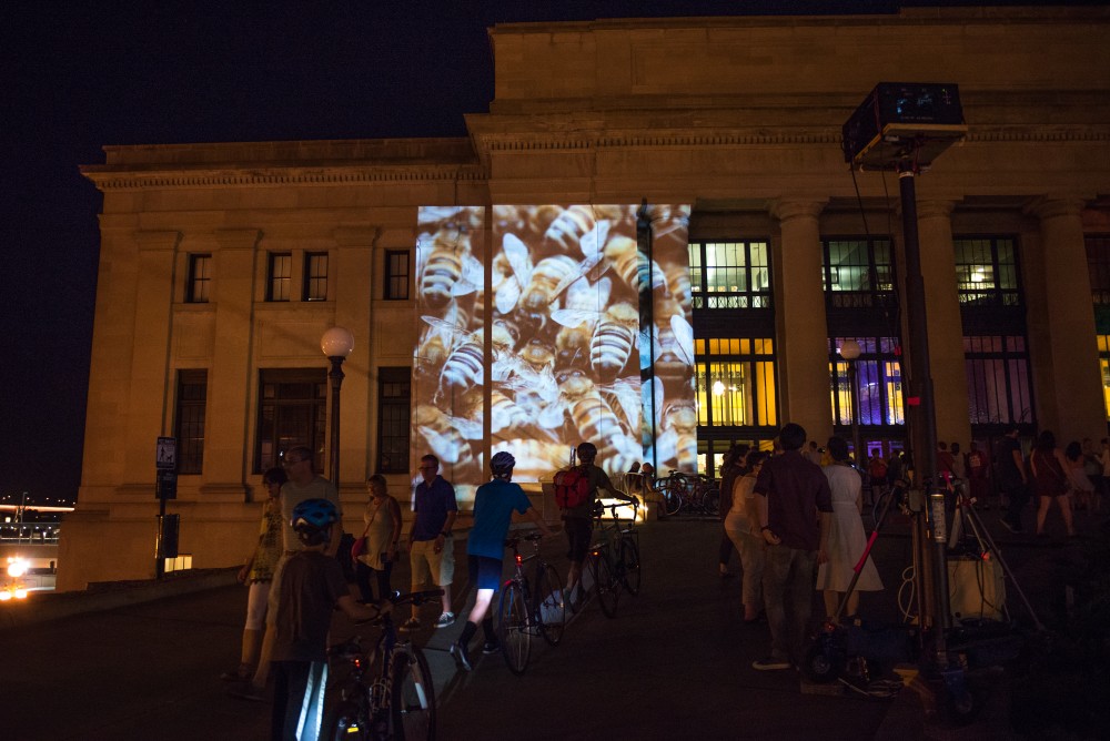 Artist Susan Brown projects a video of bees on the Union Depot in St. Paul. The piece allows visitors to voice there human support of bees and recite poems about them contestants also were allowed to voice there human support in exchange for a honey stick. 