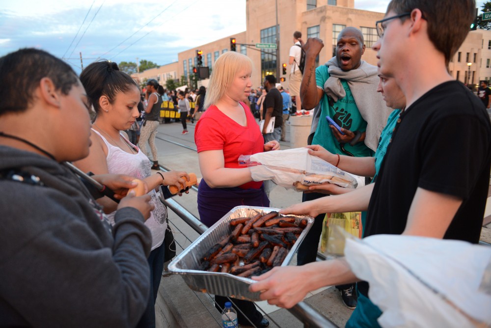 Protestors eat hot dogs on the light-rail tracks in St. Paul on Friday, June 16.