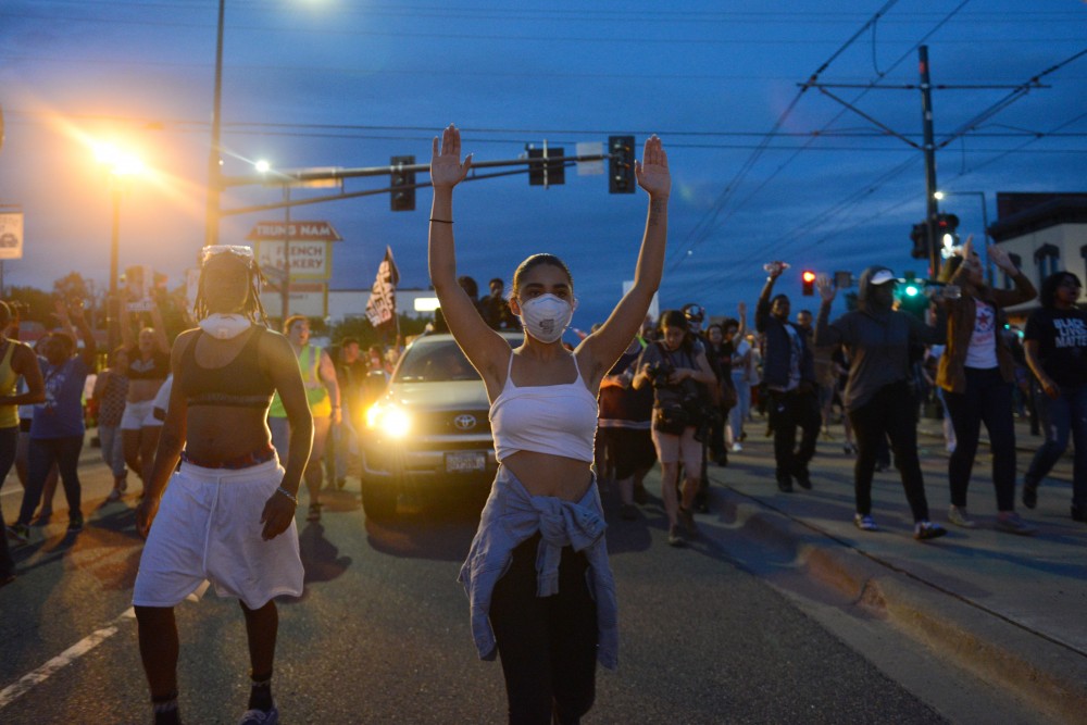 Mia Holmes raises her hands while chanting in front of a group of protestors in St. Paul on Friday, June 16.