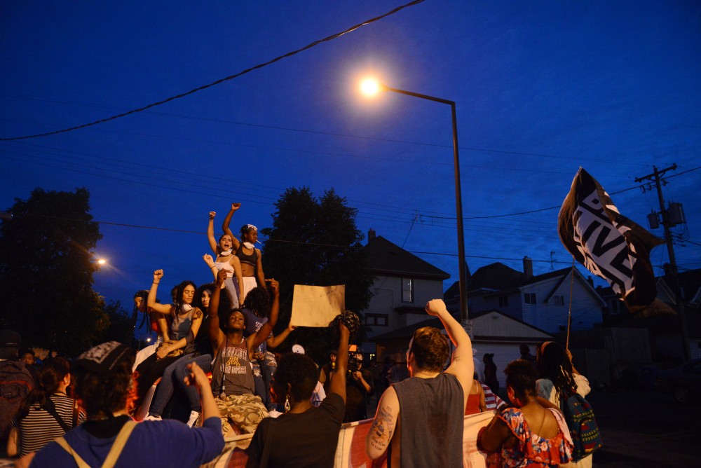 Protestors stand on top of a car while chanting in St. Paul on Friday, June 16.