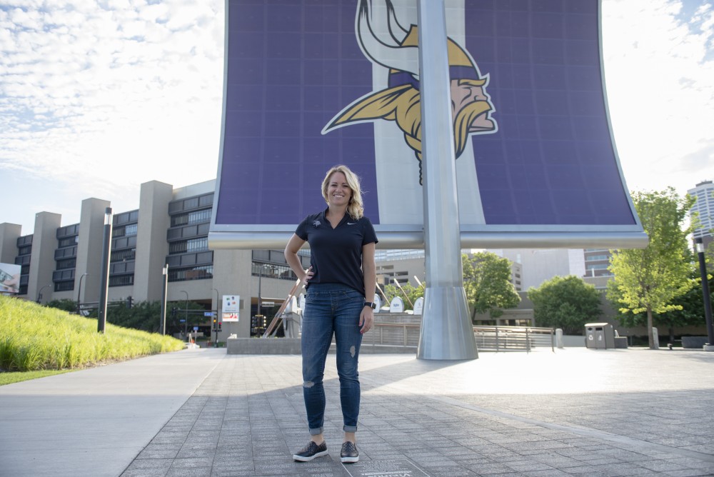 University of Minnesota alumna Kelly Kleine poses for a portrait in front of the US Bank Stadium on Wednesday. Kelly was hired as the college scouting coordinator for the Minnesota Vikings. 
