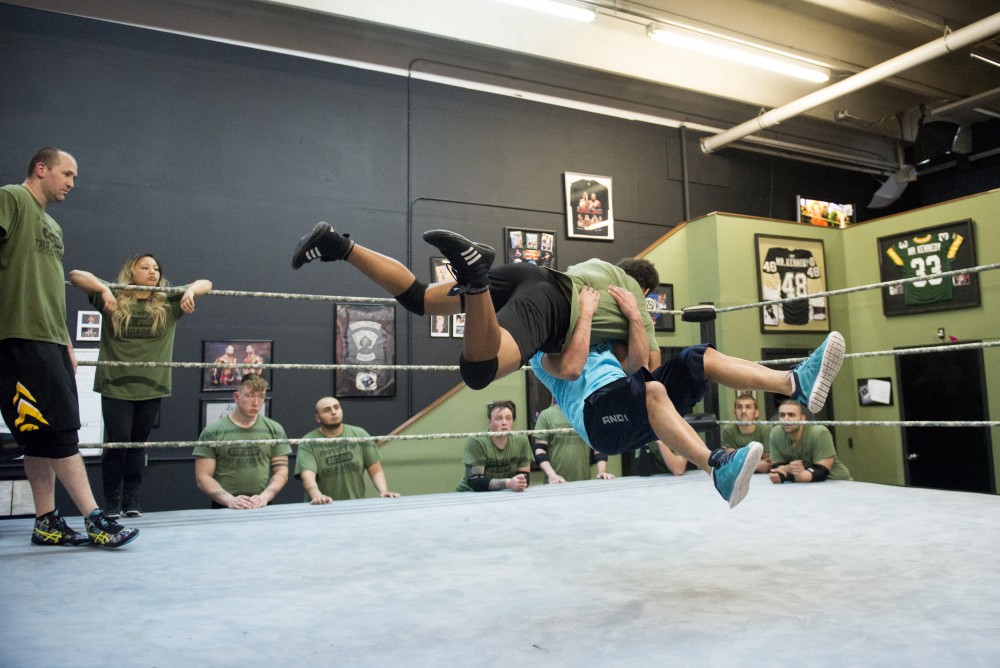 Coach Shawn Daivari demonstrates a move on a student in the ring while other students observe at The Academy in Minneapolis. 