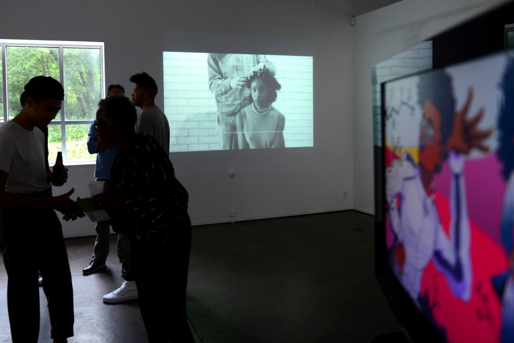 Candice Davis video projection shows audience members straightening her hair at The Shop, an art exhibition at the Public Functionary in Minneapolis, on July 1.