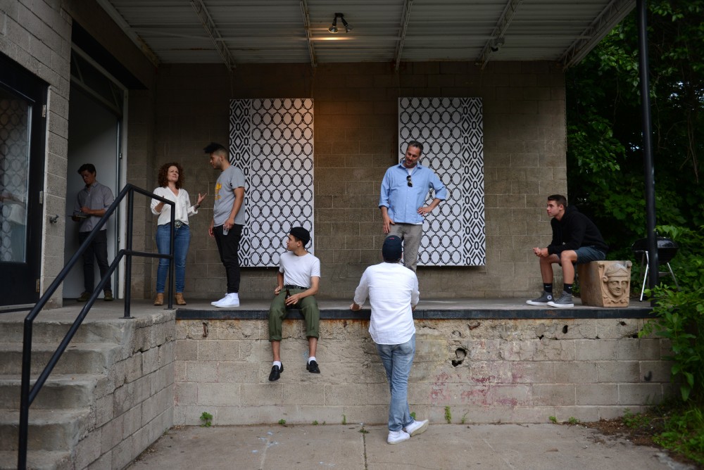 Artists and attendees sit outside The Shop, an art exhibition focused on the iconography and culture of black barbershops, at the Public Functionary in Minneapolis on July 1.