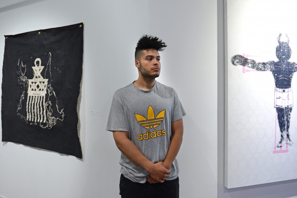 Curator and artist Crice Kahlil poses in front of some of his work hung at The Shop at the Public Functionary in Minneapolis on July 1.