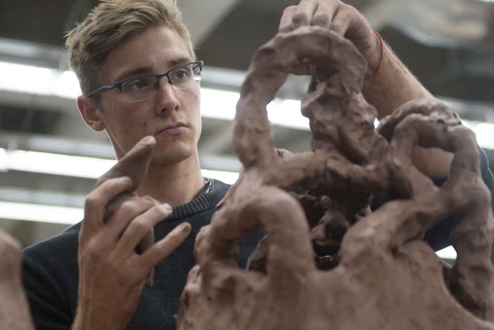 Izaak Davison-Kerwood works on his ceramic project at Regis Center For Art on Thursday. 