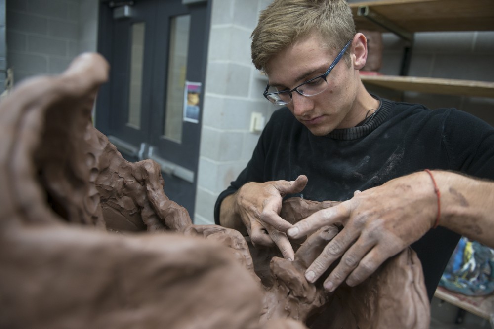 Izak Davidson works on his ceramic project at Regis Center For Art on Thursday.