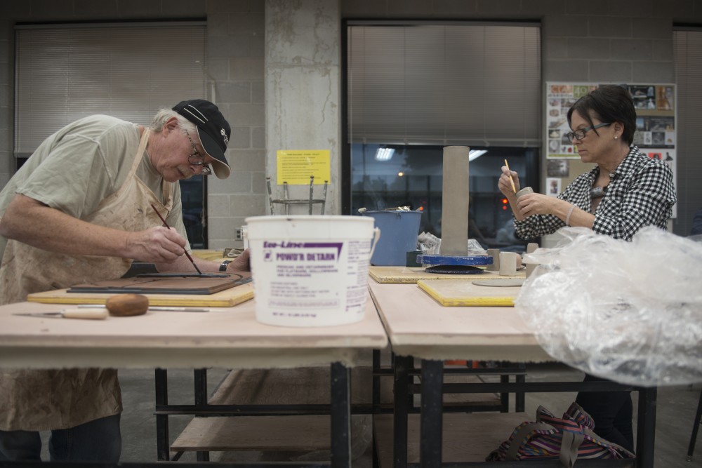 Dan Young Dixon, left, and Wendy Goodmanson work on their ceramic project at Regis Center For Art on Thursday.