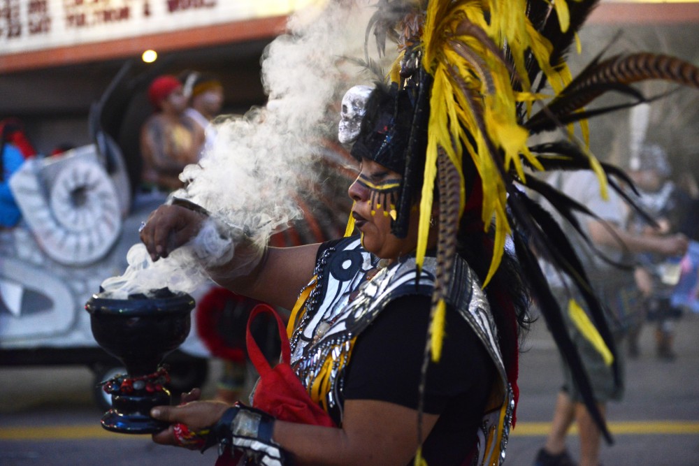 A member of Kalpulli Ketzal Coatlicue smokes sage in the 17th annual CenterPoint Energy Torchlight Parade along Hennepin Avenue on Wednesday.