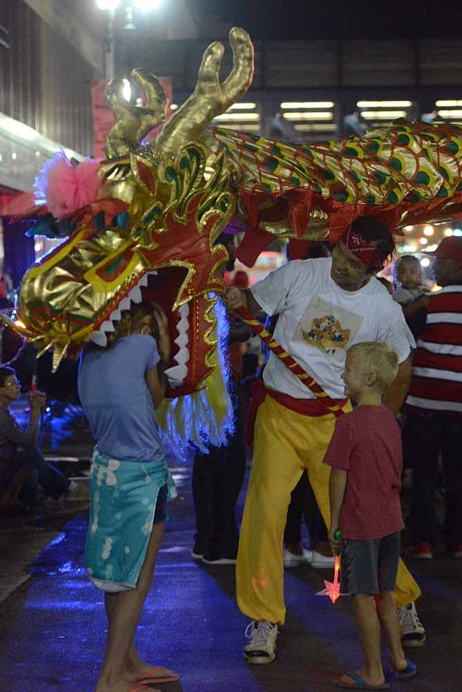 Dragon dancers of the CAAM Chinese Dance Theater play with bystanders in the 17th annual CenterPoint Energy Torchlight Parade along Hennepin Avenue on Wednesday.