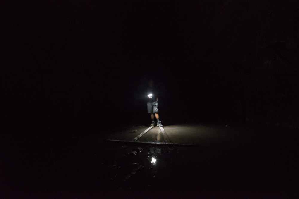 A cave explorer illuminates the ground of a secret cave beneath Minneapolis. 