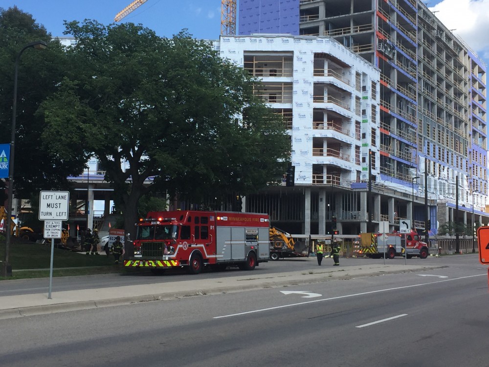 Fire trucks and first responders cordon off a stretch of University Avenue Southeast where a bulldozer ruptured a gas line Monday. Around 100 people gathered to watch as responders addressed the leak.