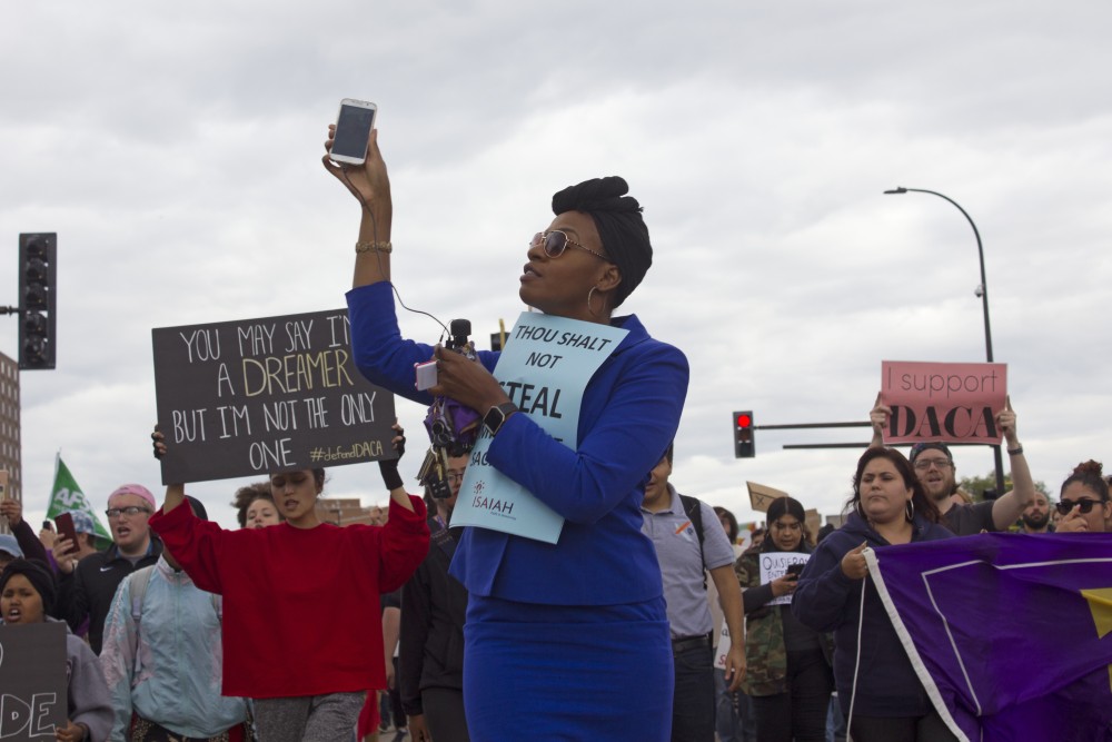 JaNaé Bates of ISAIAH documents the march with her phone on Sept. 5.
