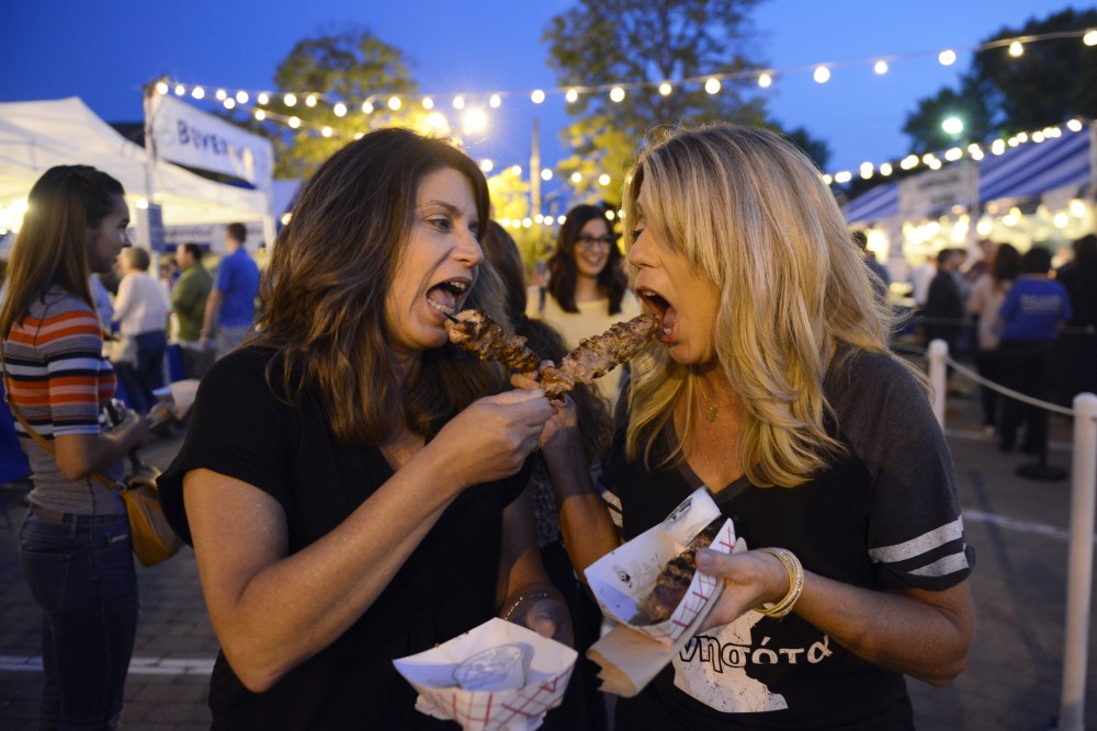 Sisters Vicki Hanson and Mary Kleve feed each other souvlaki during the Minneapolis Greek Festival at St. Marys Orthodox Church on Saturday, Sept. 9. 