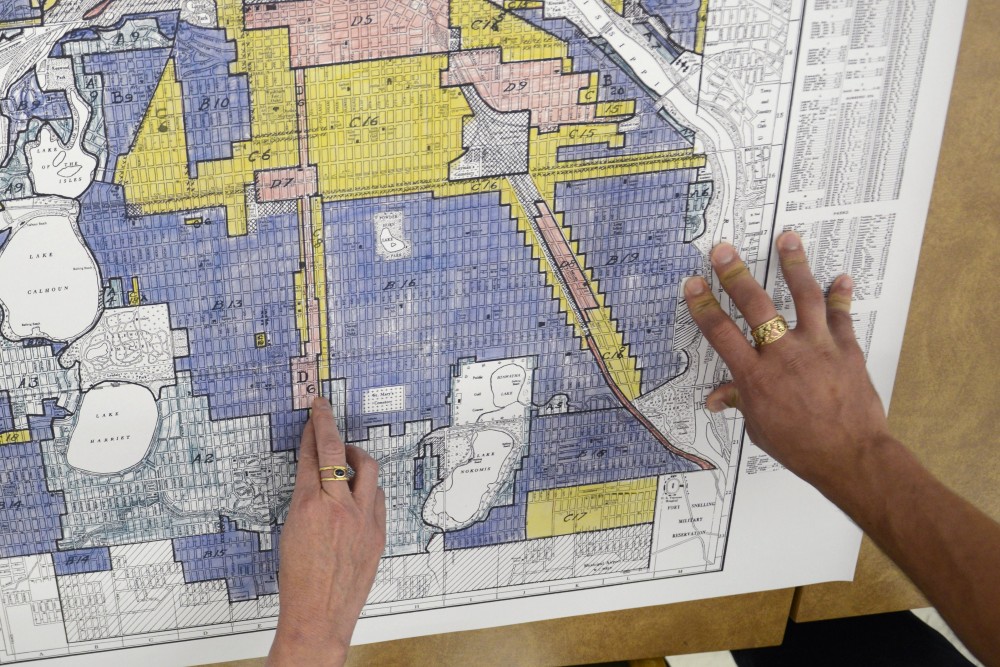 Kevin Ehrman-Solberg, Kirsten Delegated, and Penny Peterson look at city maps that show segregated areas in the metro area at Wilson Library on West Bank on Wednesday, Aug. 30. People like to believe Minneapolis had neither race nor racism, Delegated said.