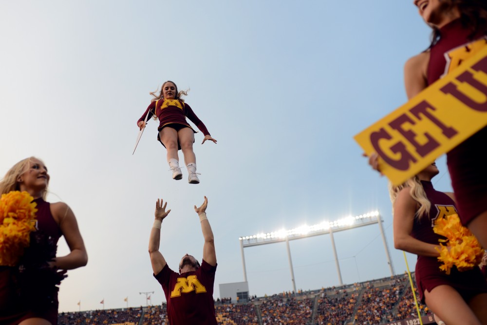 A cheerleader is lifted into the air at TCF Bank Stadium on Thursday, August 31, 2017.