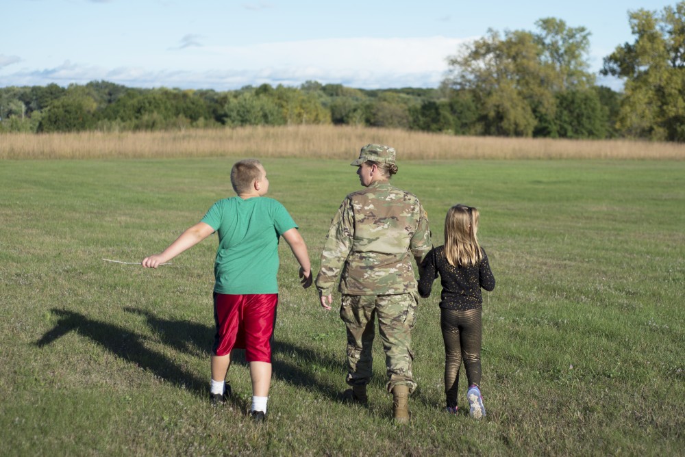 Janice Hawkins and her children Mason and MaryJean walk onto the Arden Hills Armory landing zone in Arden Hills on Tuesday, Oct. 3.   