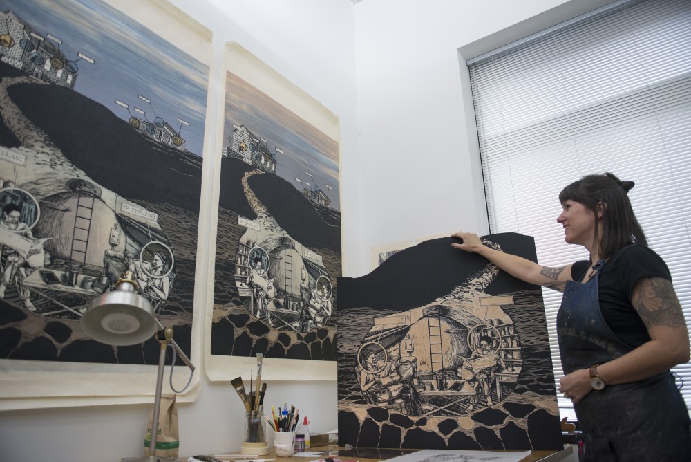 Professor and printmaker Edie Overturf displays her work in her studio space with woodcut storytelling artwork on display on Monday, Oct. 9. Edie is one of five emerging Minnesota artists to receive the Jerome Foundation Fellowship award this year.  