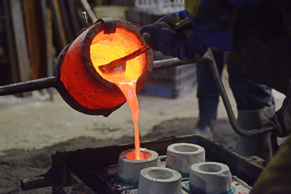 Students pour aluminum into a mold at the Regis foundry at the CLAs second annual Arts Quarter Festival on Wednesday, Oct. 11. 