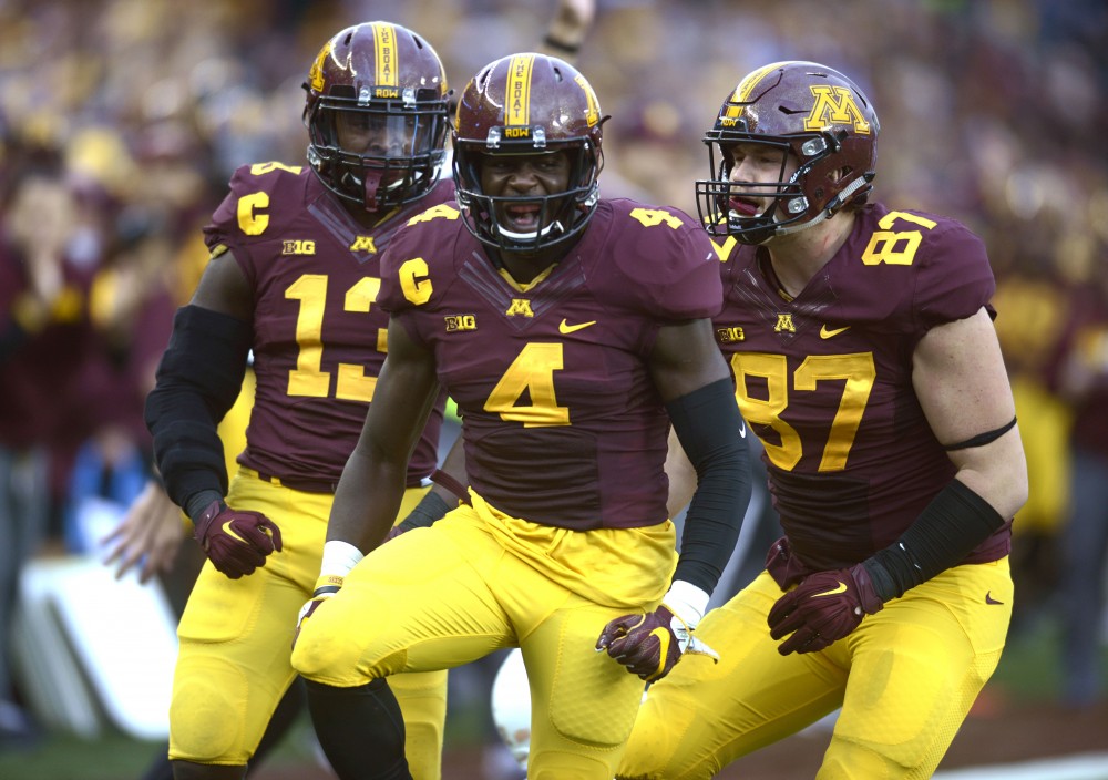 Defensive back Adekunle Ayinde celebrates with his teammates after a sack against Illinois at TCF Bank Stadium during the Homecoming game on Saturday, Oct. 21.