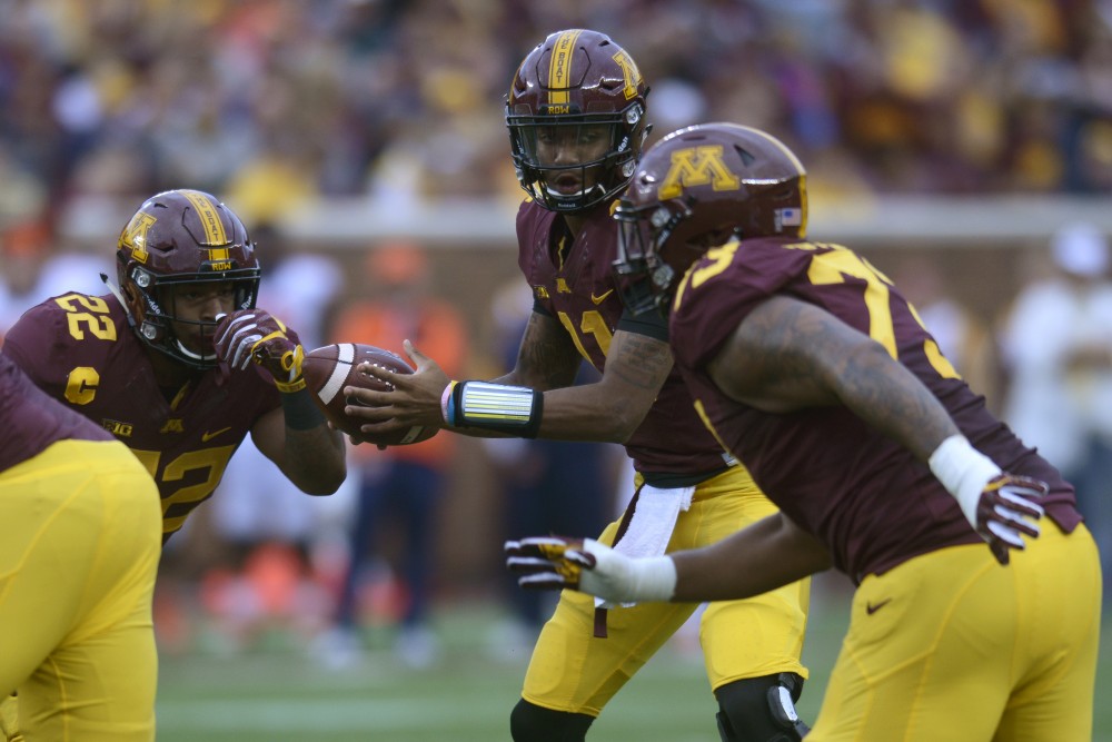 Quarterback Demry Croft hands the ball off to running back Kobe McCrary during the homecoming game on Saturday, Oct. 21 at TCF Bank Stadium. The Gophers defeated Illinois 24-17.