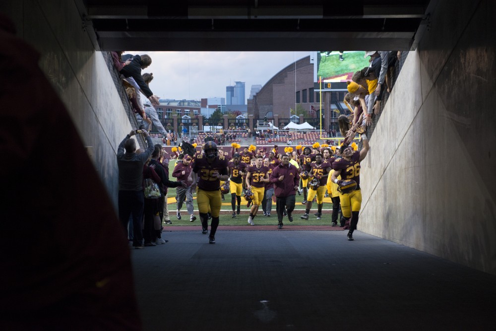 Gophers football players run off the field after winning against Illinois 24-17 for their homecoming game on Saturday, Oct. 21 at TCF Bank Stadium. 
