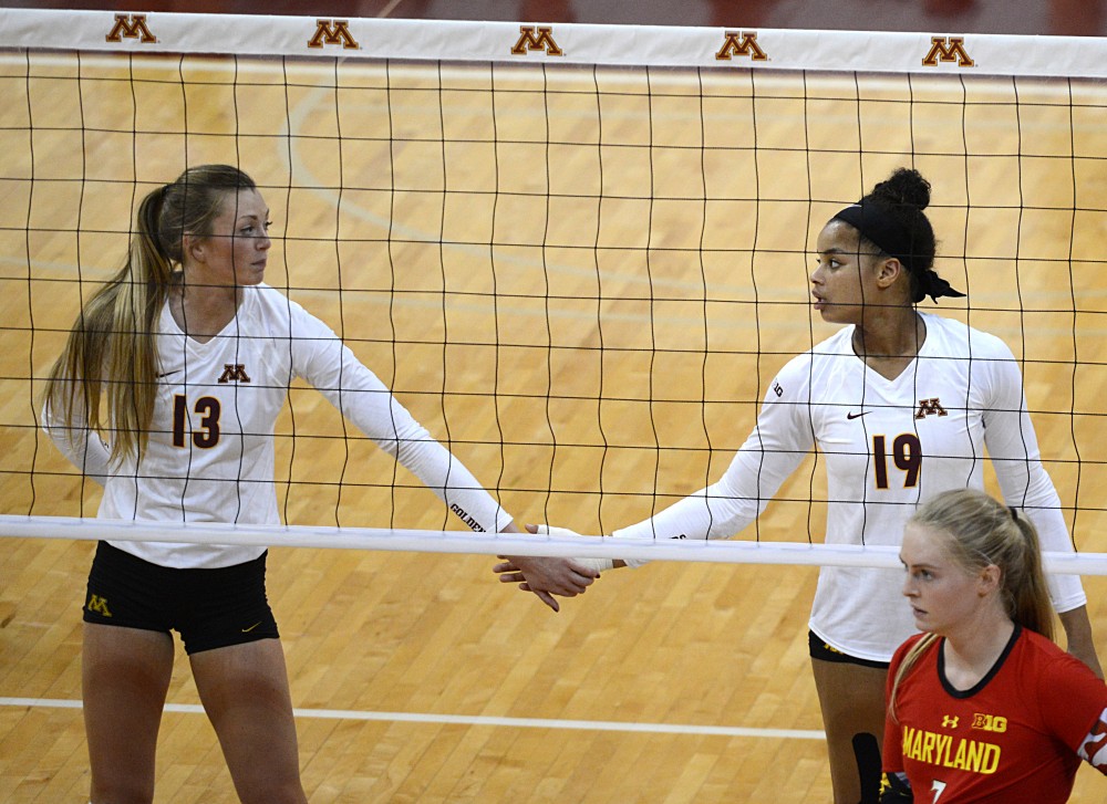 Gophers Molly Lohman, left, and Alexis Hart touch hands after a point against Maryland on Sept. 23, 2016 in the Sports Pavillon.