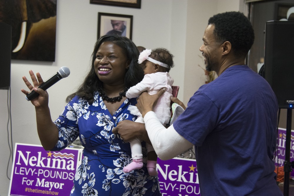 Nekima Levy-Pounds prepares to address the crowd with her daughter during her Election Day party at her campaign headquarters on Nov. 7.