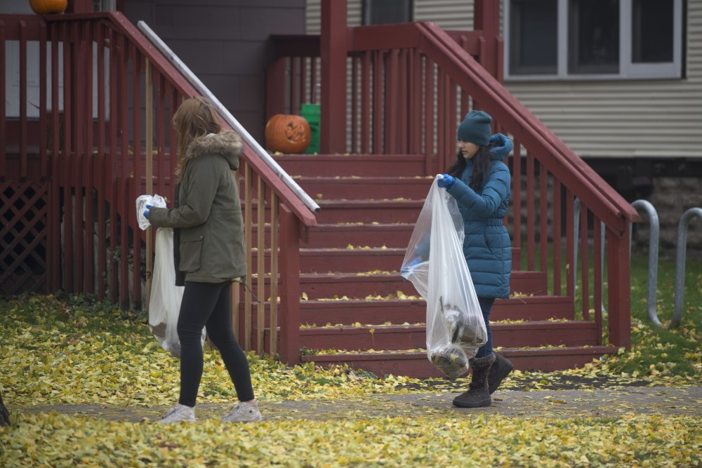 Two students walk through Dinkytown in search of trash on Sunday, Nov. 5.