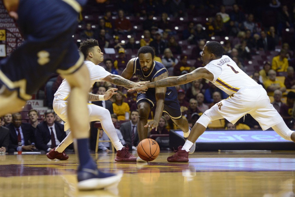Nate Mason, left, and Dupree McBrayer, right, attempt to steal the ball from Concordia on Thursday, Nov. 2, 2017 at Williams Arena.