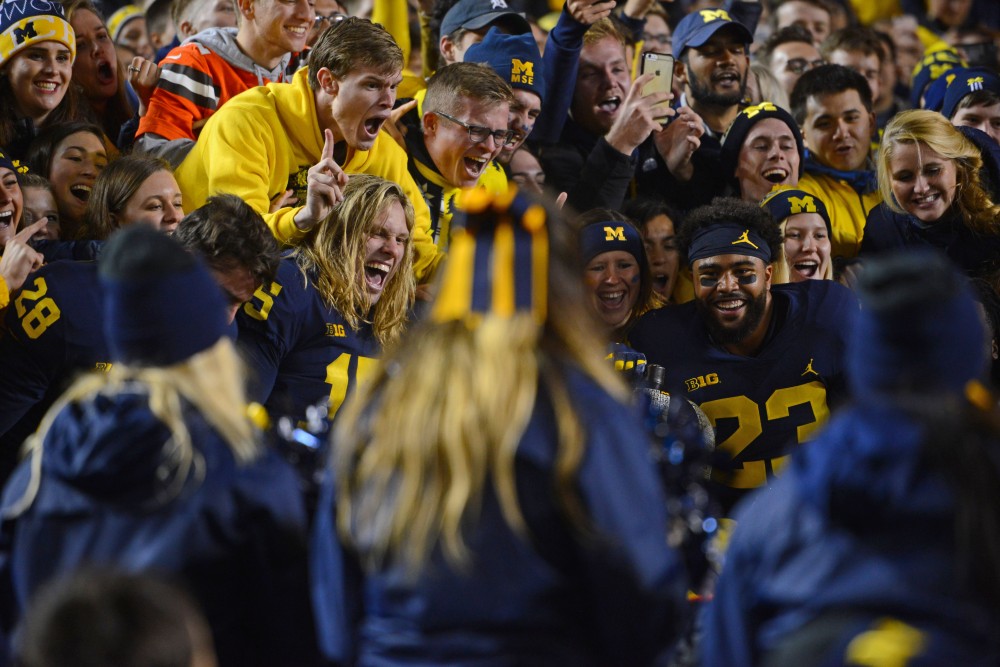 Michigan players climb into their student section with the Little Brown Jug after winning against Minnesota on Saturday, Nov. 4, 2017 in Ann Arbor, Mich. 