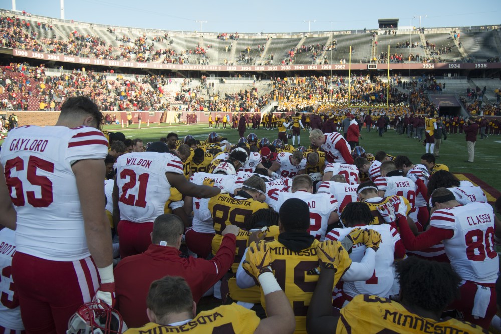 Players from both the University of Minnesota and Nebraska take a knee on the center of field after the game on at TCF Bank Stadium on Saturday, Nov. 11.