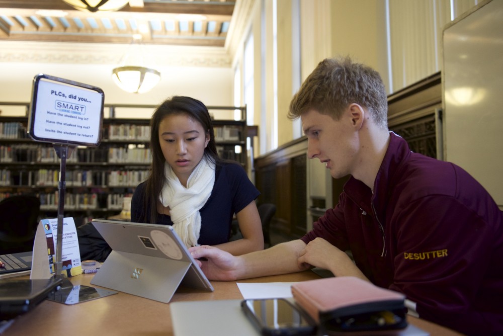 Tutor Noah DeSutter helps Sara Green at the SMART learning commons at Walter Library on Monday, Nov. 13.