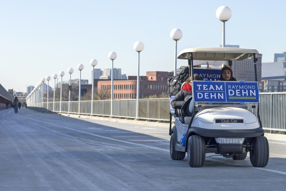 Campaigners for Raymond Dehn, senior Sonia Neculescu and sophomore Aisha Chughtai, offer rides across the Washington Avenue Bridge on Tuesday, Nov. 7.