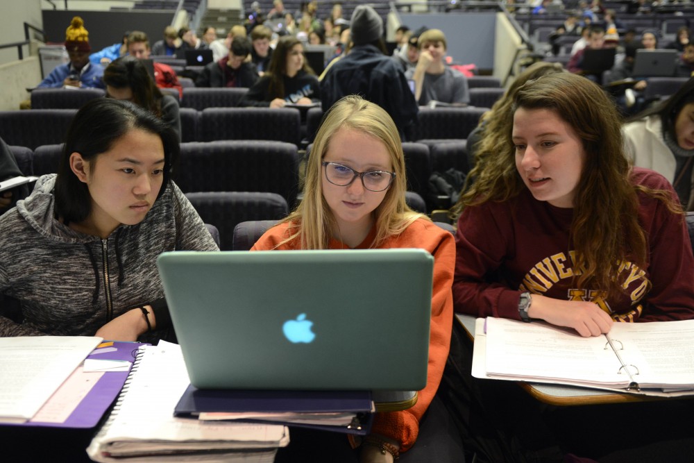 Lauren Kalvin, right, Emma Dombrow, center, and Pakou Lee, left, work together on a class activity during Biology 1001 on Tuesday Nov. 21 in Willey Hall on West Bank. 