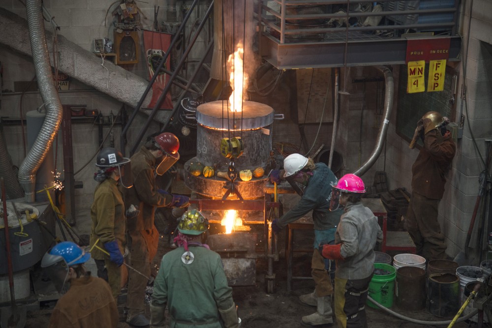 Participants engage in the Universitys Art Departments 31st annual Iron Pour at the Regis Foundry on Tuesday, Nov. 21.