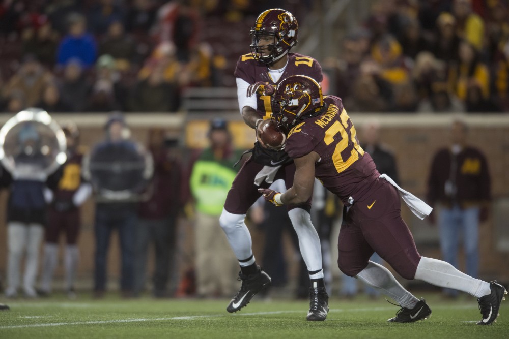 Quarterback Demry Croft hands the ball off to running back Kobe McCrary on Saturday, Nov. 25 at TCF Bank Stadium. The Badgers beat the Gophers 31-0.