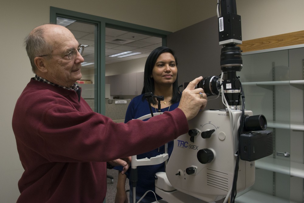 Director of the Center for Drug Design Robert Vince and assistant professor at the Center for Drug Design Swati More pose for portraits with their retinal hyper-spectral imaging camera at the Phillips-Wangensteen Building on Friday, Dec. 1. This camera is used for the early detection of Alzheimers disease.