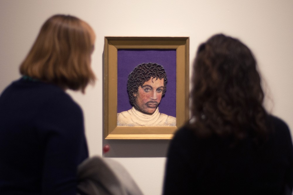 Elizabeth Wolkoff, left, and Vivian Wolkoff look on at a portrait of Prince created by Lillian Cotton the preview party for the Prince from Minneapolis exhibition look on at a portrait of Prince at the Weisman Art Museum on Friday, Dec. 8.