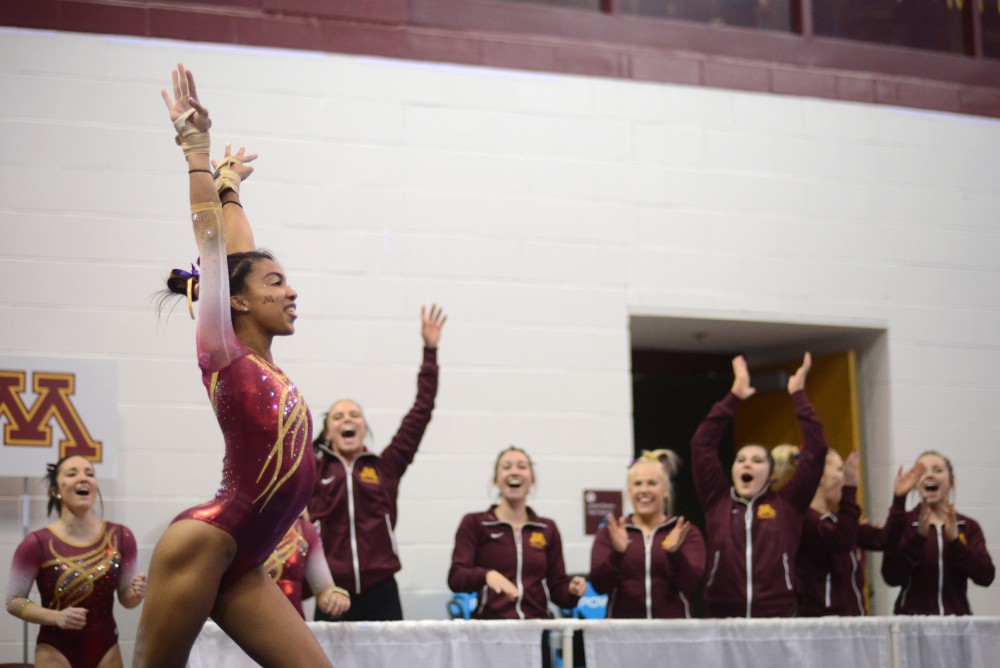 Senior Ciara Gardner is cheered on by her teammates while posing in the middle of her floor routine on Saturday, Jan. 13.