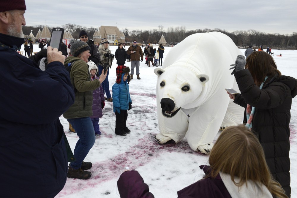 Attendees interact with a polar bear puppet during the Art Shanty Projects event on Lake Harriet in Minneapolis on Saturday, Jan. 20.