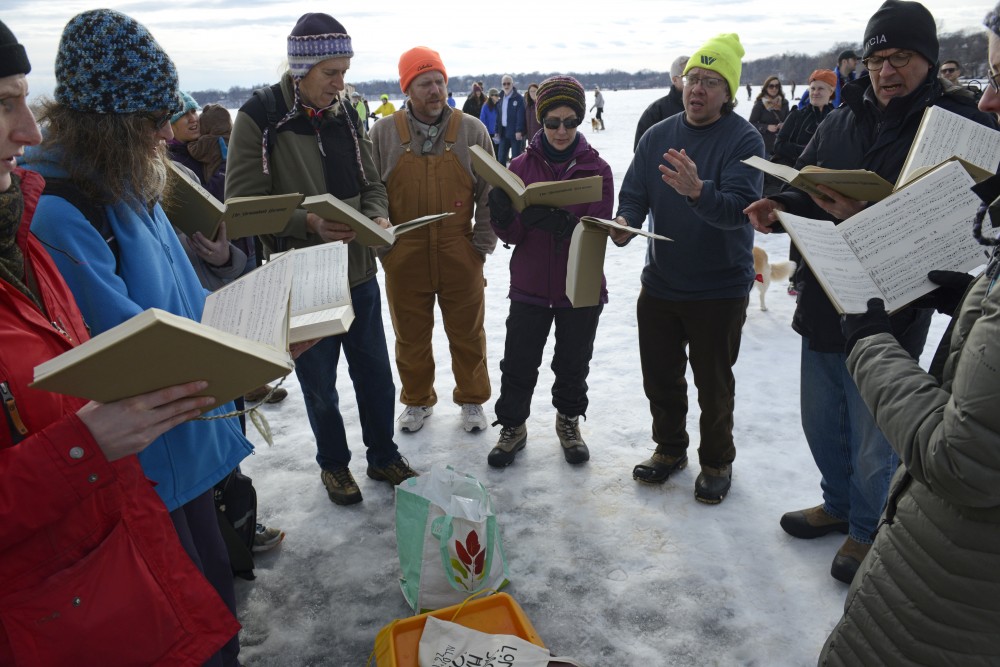 Attendees of the Art Shanty Project join together to sing from songbooks on Lake Harriet in Minneapolis on Saturday, Jan. 20