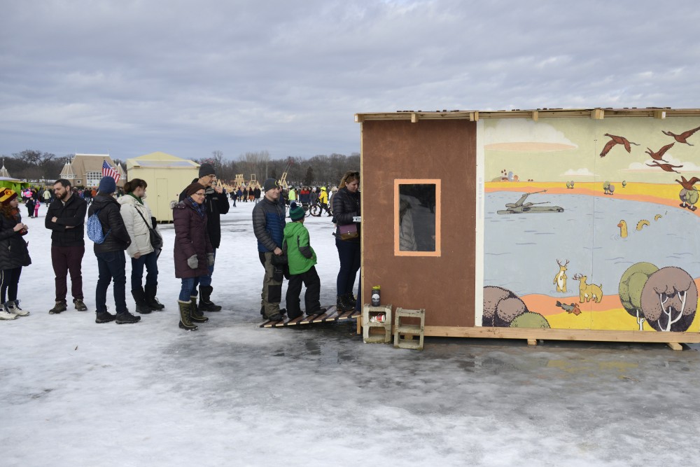 Attendees line up to enter a shanty during the Art Shanty Projects event on Lake Harriet in Minneapolis on Saturday, Jan. 20.