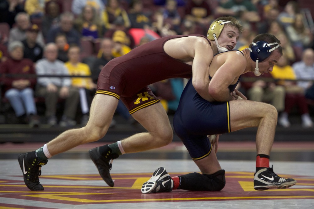 Senior Nick Wanzek at 165 wrestles with No. 5 Logan Massa during the dual against Michigan on Sunday. The Gophers lost to Michigan, their first loss of the season.
