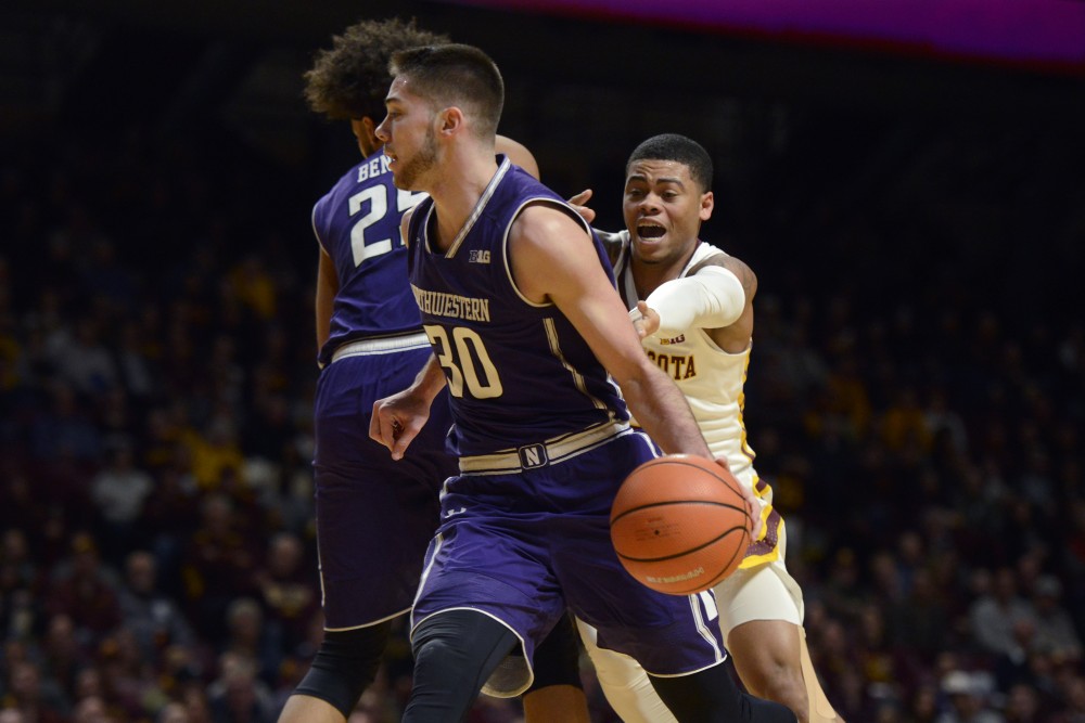 Senior guard Nate Mason reaches after Northwestern guard Bryant McIntosh during a game at Williams Arena on Tuesday. 