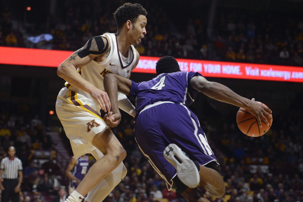 Sophomore guard Amir Coffey follows Northwestern forward Vick Law during a game at Williams Arena on Tuesday. 