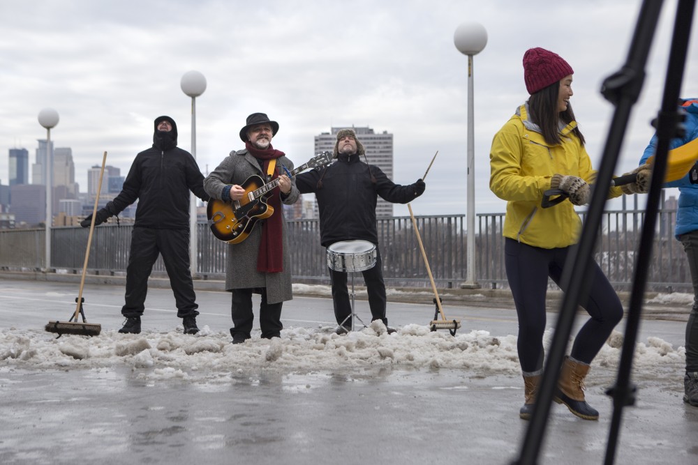 Communications professor Mark Pedelty performs with a band and University dance majors for a music video on Saturday, Jan. 20 on the Washington Avenue bridge. The music video aims to communicate the effects of using salt during the winter to audiences like local business owners for his project Field to Media: Applied Musicology for a Changing Climate.